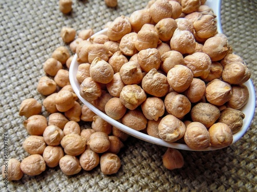 chickpeas on a spoon against a background of coarse cloth