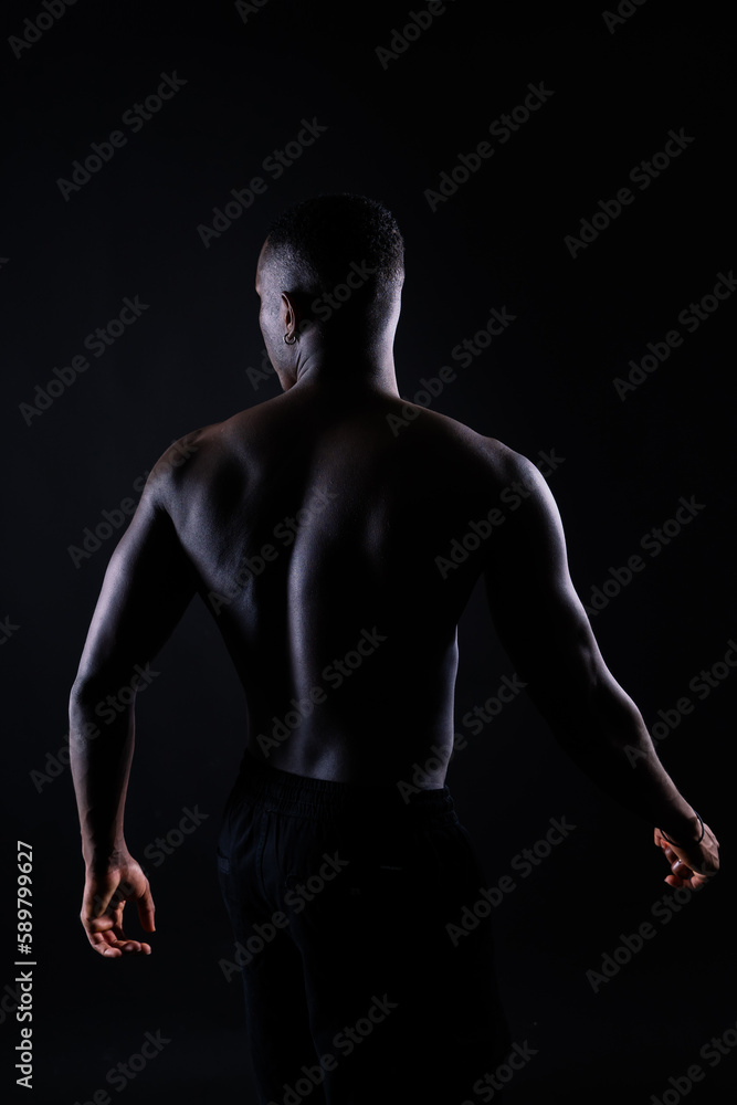 Portrait of an athletic african american man topless, black background Portrait of an athletic african american man topless, black background