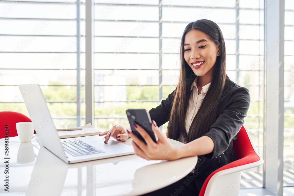 Young Asian business woman using smartphone to login to corporate system Young Asian business woman using smartphone to login to corporate system