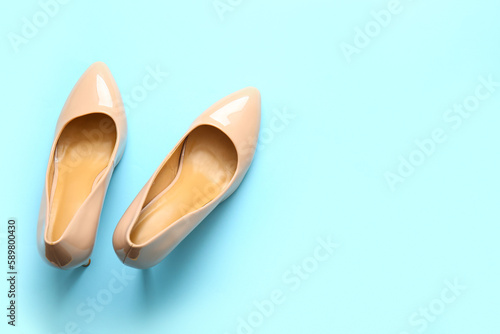 Pair of stylish high heeled shoes on light blue background