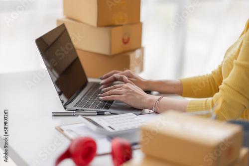 Portrait of Asian young woman SME working with a box at home the workplace.start-up small business owner, small business entrepreneur SME or freelance business online and delivery concept.  © David