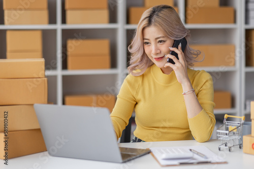 Portrait of Asian young woman SME working with a box at home the workplace.start-up small business owner, small business entrepreneur SME or freelance business online and delivery concept. 