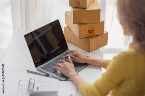 Portrait of Asian young woman SME working with a box at home the workplace.start-up small business owner, small business entrepreneur SME or freelance business online and delivery concept.
