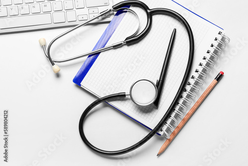 Stethoscope, notebook and pc keyboard on doctor's table