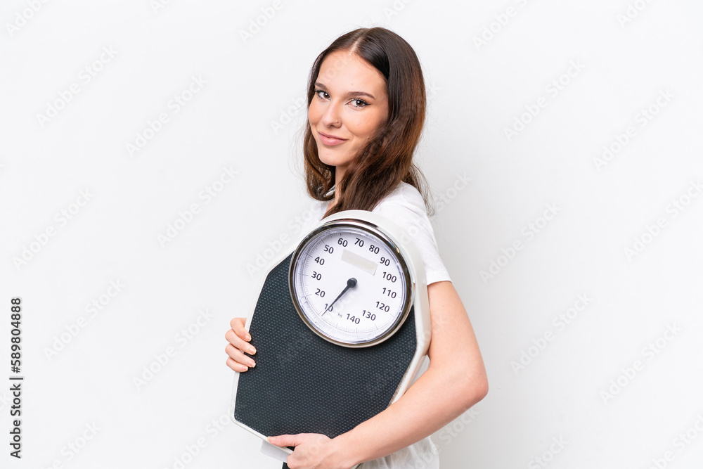 Young caucasian woman isolated on white background with weighing machine Young caucasian woman isolated on white background with weighing machine
