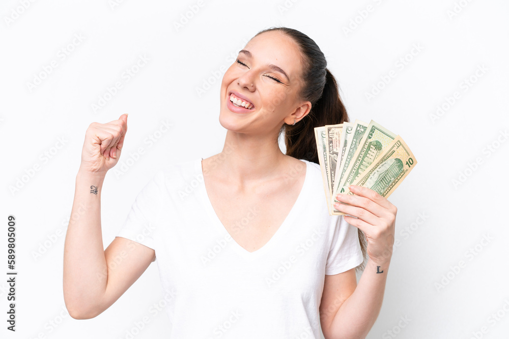 Young caucasian woman taking a lot of money isolated on white background celebrating a victory Young caucasian woman taking a lot of money isolated on white background celebrating a victory