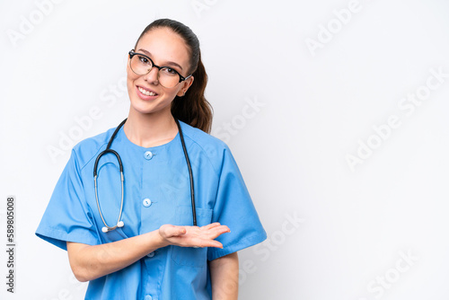 Young caucasian surgeon doctor woman isolated on white background presenting an idea while looking smiling towards