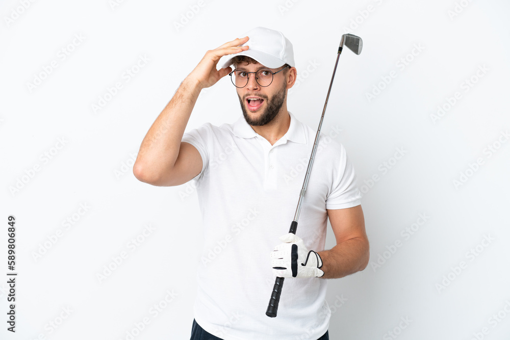 Handsome young man playing golf isolated on white background doing surprise gesture while looking to the side Handsome young man playing golf isolated on white background doing surprise gesture while looking to the side