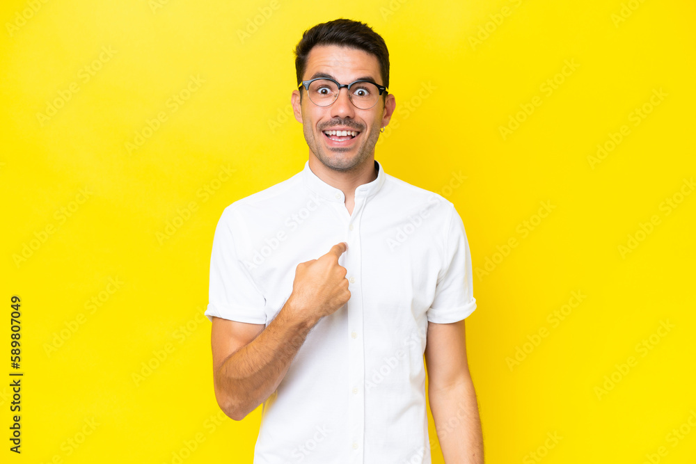 Young handsome man over isolated yellow background with surprise facial expression Young handsome man over isolated yellow background with surprise facial expression
