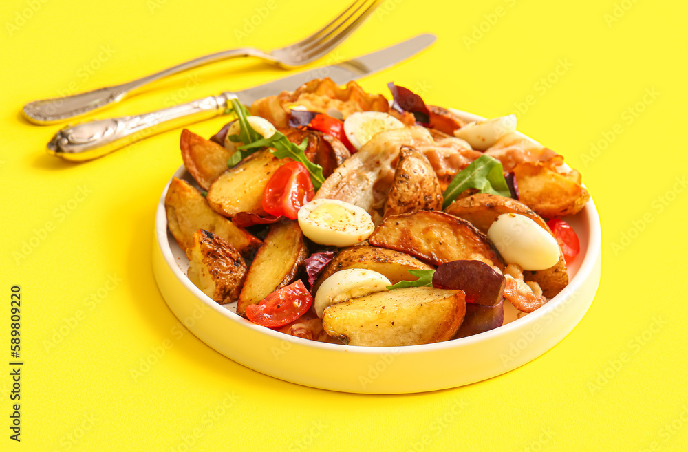 Plate of tasty potato salad with eggs, tomatoes and bacon on yellow background Plate of tasty potato salad with eggs, tomatoes and bacon on yellow background