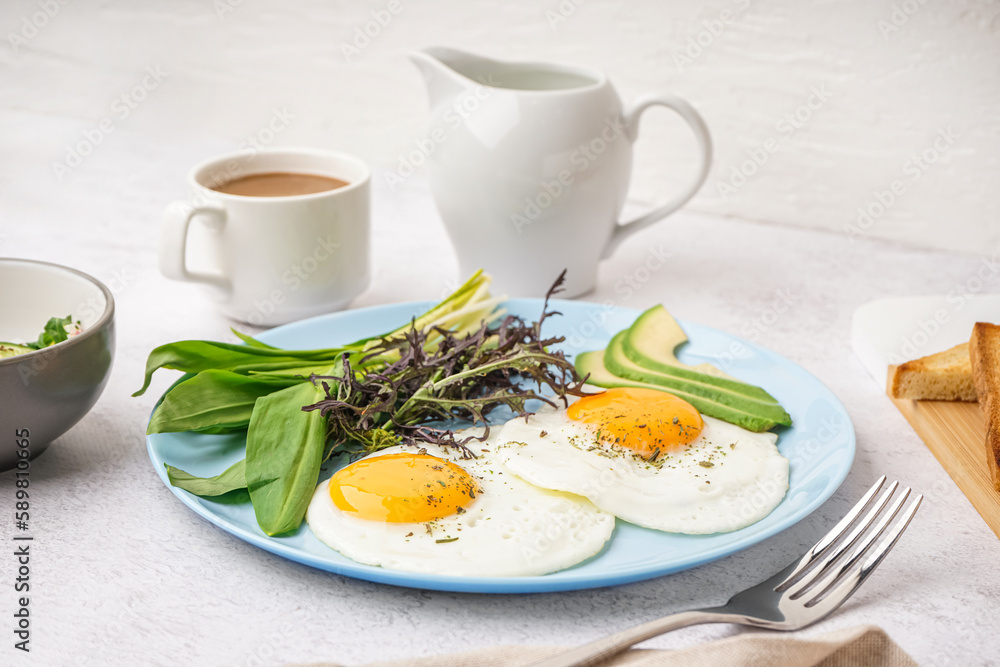 Plate with tasty fried eggs, coffee and greens on light table Plate with tasty fried eggs, coffee and greens on light table