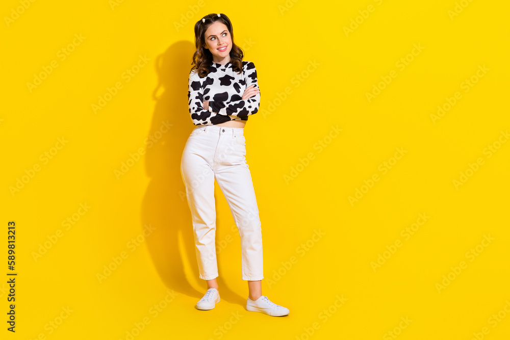 Fototapeta premium Full length photo of funky dreamy lady dressed cowskin shirt arms folded looking empty space isolated yellow color background