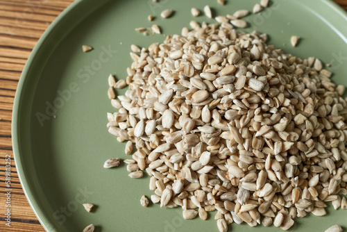Bild auf Leinwand Purified sunflower seeds on a green plate