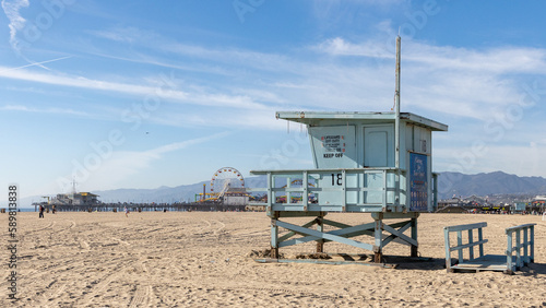 A lifeguard tower on Santa Monica beach with pier in the background located in California USA taken on February 5th 2023