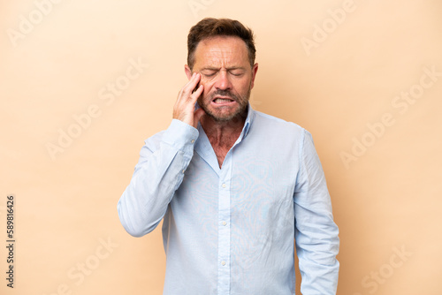 Middle age caucasian man isolated on beige background with toothache