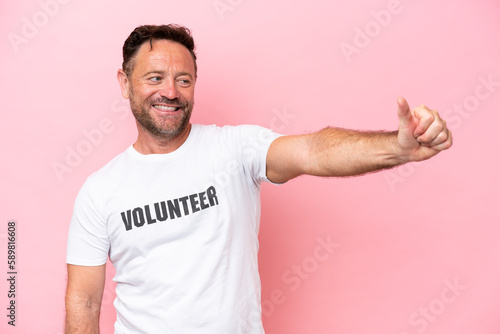 Middle age volunteer man isolated on pink background isolated on pink background giving a thumbs up gesture