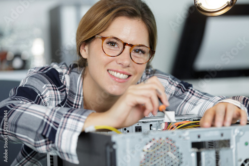woman repairing computer with screwdriver