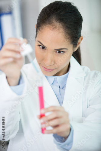 doctor drips from a pipette into a test tube