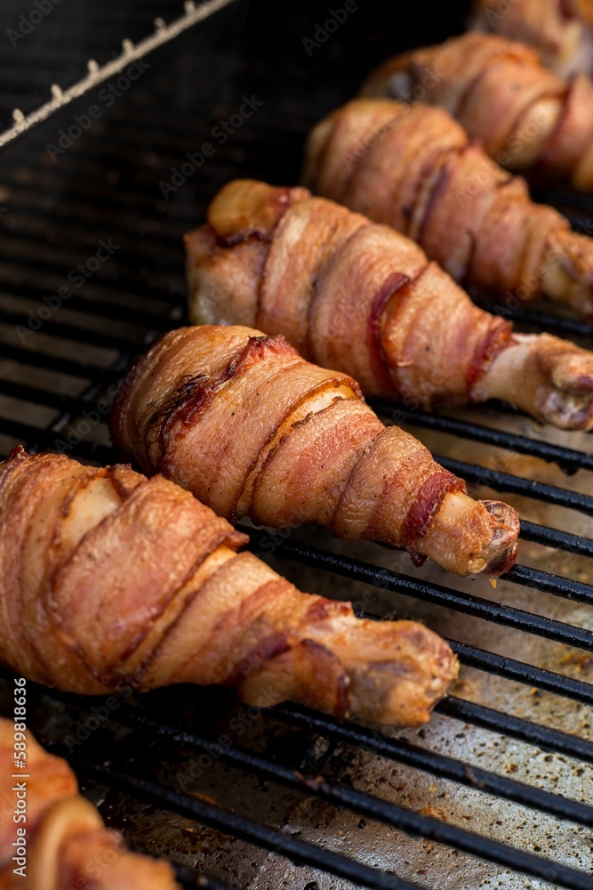 Grill with chicken legs wrapped in bacon