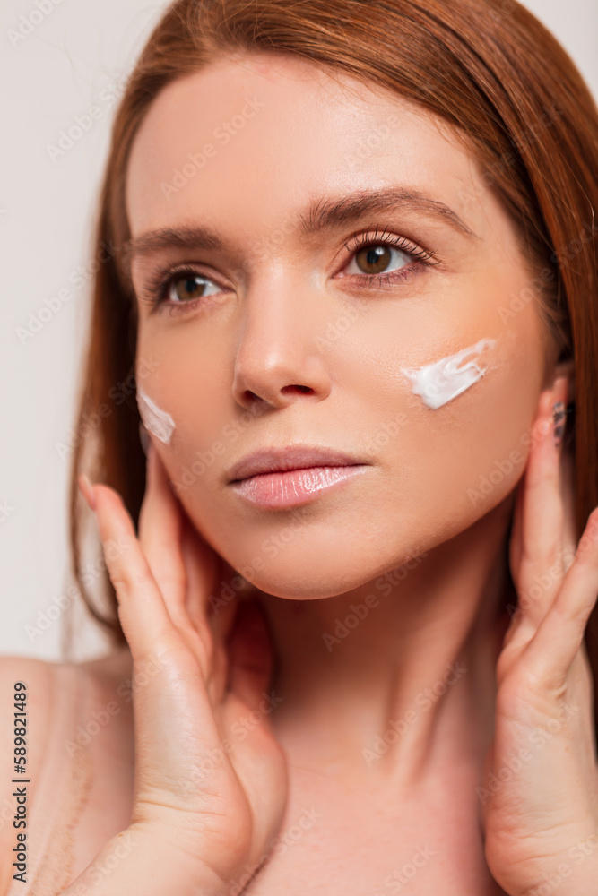 Beautiful young fresh redhead scandinavian woman with cream on face skin in studio. Beauty and skin care Beautiful young fresh redhead scandinavian woman with cream on face skin in studio. Beauty and skin care