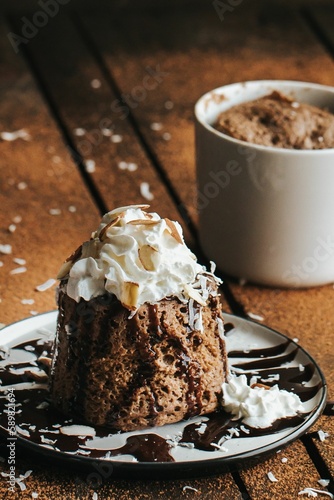 Vertical shot of a chocolate cake and a white cup on the wooden background
