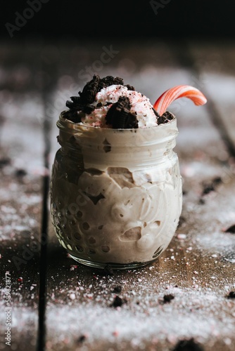Closeup shot of a delicious cookie shake in a glass jar surrounded by icing sugar