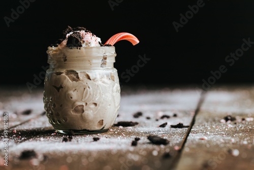 Closeup shot of a delicious cookie shake in a glass jar surrounded by icing sugar