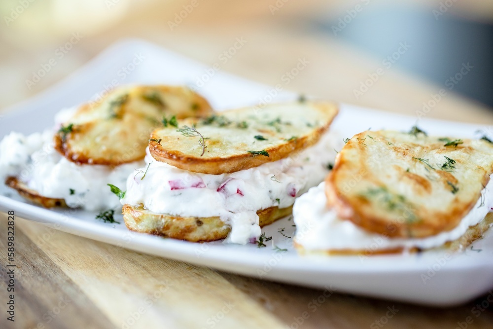 Closeup shot of potato sandwiches made of two potato slices and loaded with greek yogurt Closeup shot of potato sandwiches made of two potato slices and loaded with greek yogurt
