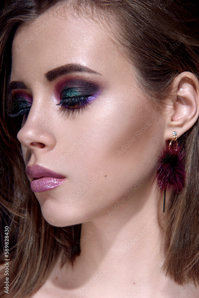 Fototapeta premium Beautiful woman with bright multicolor celebration make up Chic evening make-up. Fashion retouched portrait.