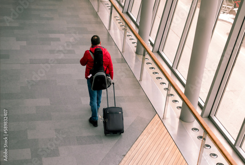 Singel man traveler with a roller bag in modern airport