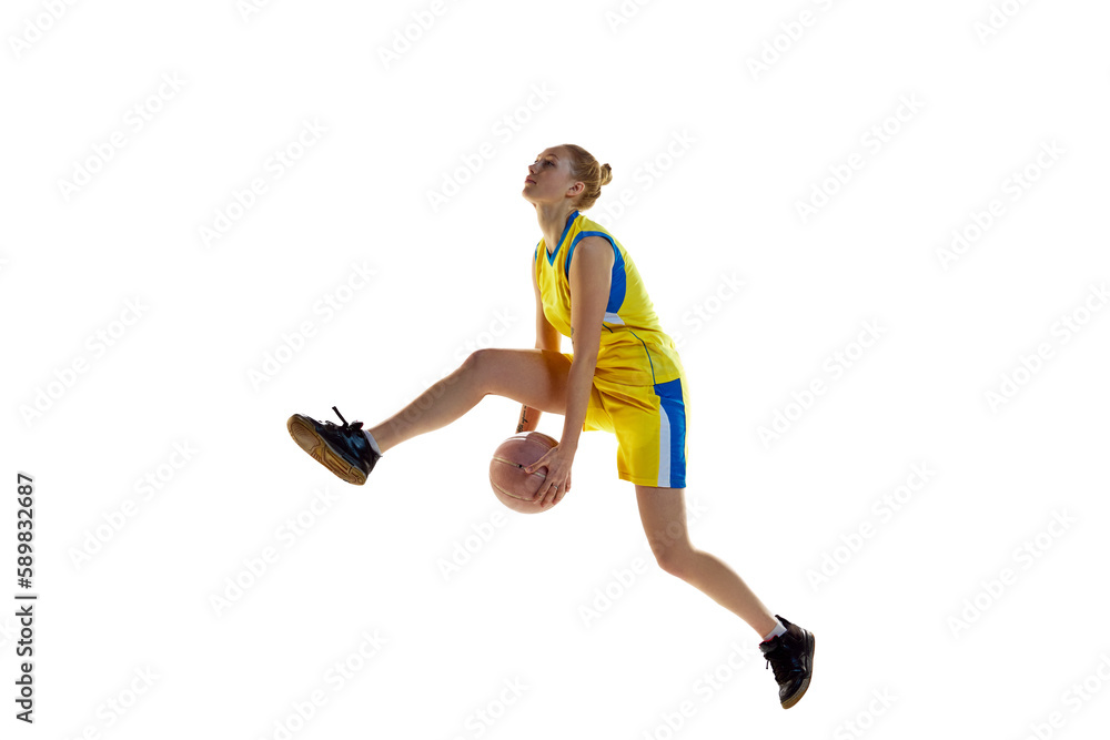 Scoring a goal. Young athletic girl, basketball player in motion, training, jumping with ball against white studio background. Concept of professional sport, hobby, healthy lifestyle, action, motion