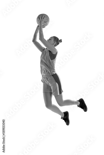 Black and white image of young athletic girl in jump  playing basketball against white studio background. Concept of professional sport  hobby  healthy lifestyle  action and motion