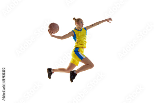 Young girl in motion, throwing ball in jump, playing, training basketball against white studio background. Concept of professional sport, hobby, healthy lifestyle, action and motion