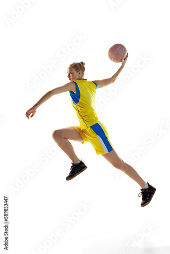 Full-length image of young girl, basketball player in motion, playing, throwing ball against white studio background. Concept of professional sport, hobby, healthy lifestyle, action and motion