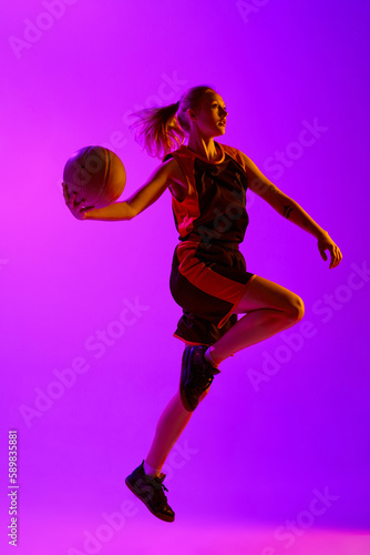 Full-length image of young girl, female basketball player in motion, playing against white studio background. Winning game. Concept of professional sport, hobby, healthy lifestyle, action and motion © master1305
