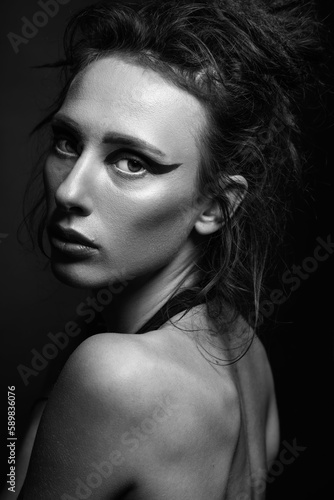 Fashion and make-up concept. Studio portrait of beautiful woman with red shadows, long and dark dreadlocks hair looking at camera with seductive look. Studio shot. Black and white image