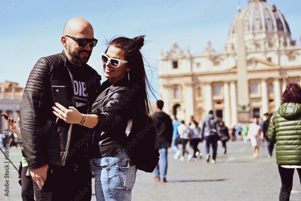 Happy smiling beautiful Tourists couple traveling at Rome, Italy, poses and making photos in front of Vatican City at, Rome, Italy.Concept of Italian gastronomy and travel. Italian couple having Happy smiling beautiful Tourists couple traveling at Rome, Italy, poses and making photos in front of Vatican City at, Rome, Italy.Concept of Italian gastronomy and travel. Italian couple having