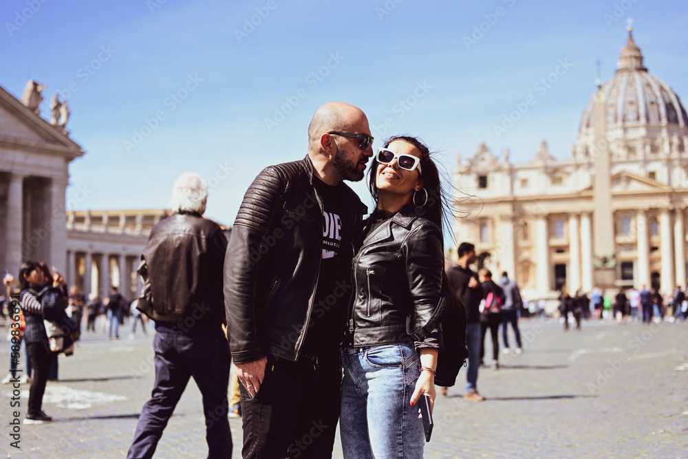Obraz premium Happy smiling beautiful Tourists couple traveling at Rome, Italy, poses and making photos in front of Vatican City at, Rome, Italy.Concept of Italian gastronomy and travel. Italian couple having