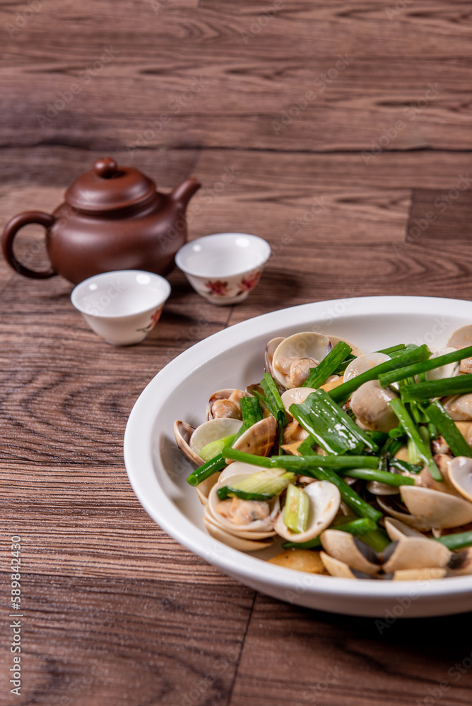 braised fresh White Sea clam shell in Chinese wine ginger onion and scallion soup in white bowl on wood table luxury halal food fine dining restaurant seafood menu