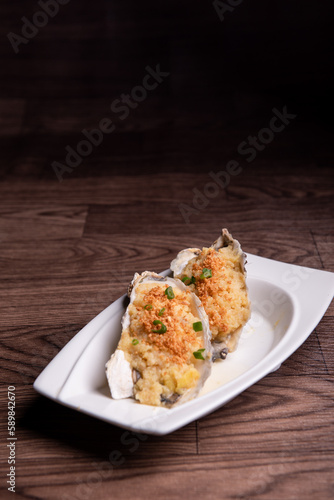 fresh western seafood steamed 2 big oyster shell with garlic ginger sauce in white plate on wood table luxury halal food fine dining restaurant menu