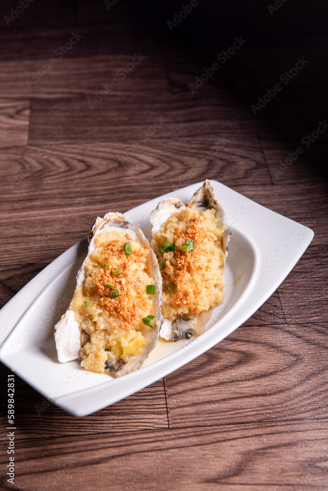 fresh western seafood steamed 2 big oyster shell with garlic ginger sauce in white plate on wood table luxury halal food fine dining restaurant menu