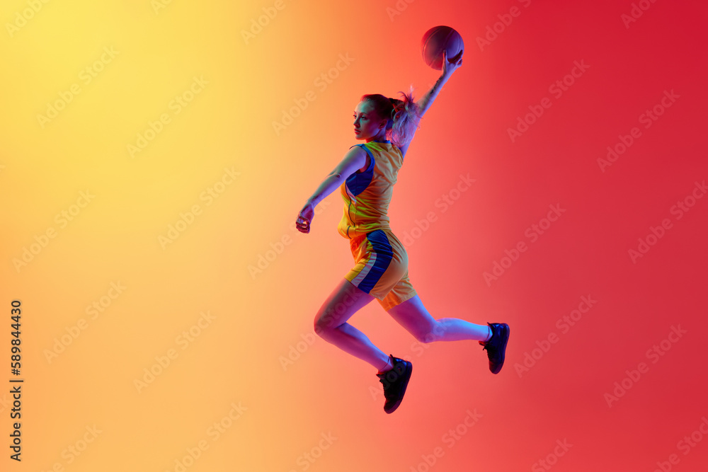 Slam dunk. Dynamic image of active female basketball player in motion during game throwing ball