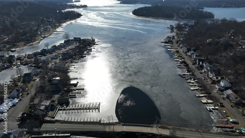 Aerial view of the Hopatcong lake covered in ice, dry trees and old houses around it in New Jersey photo