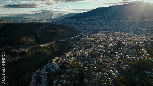 Bird's eye view of houses in green hills on a sunny day in Quito, Ecuador