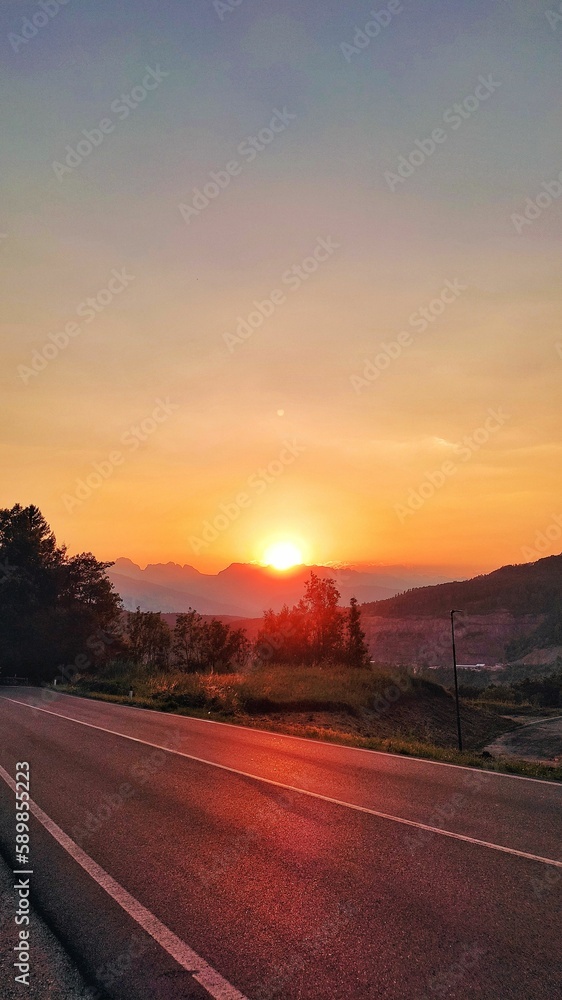 Vertical shot of a beautiful bright sunset over the highway road