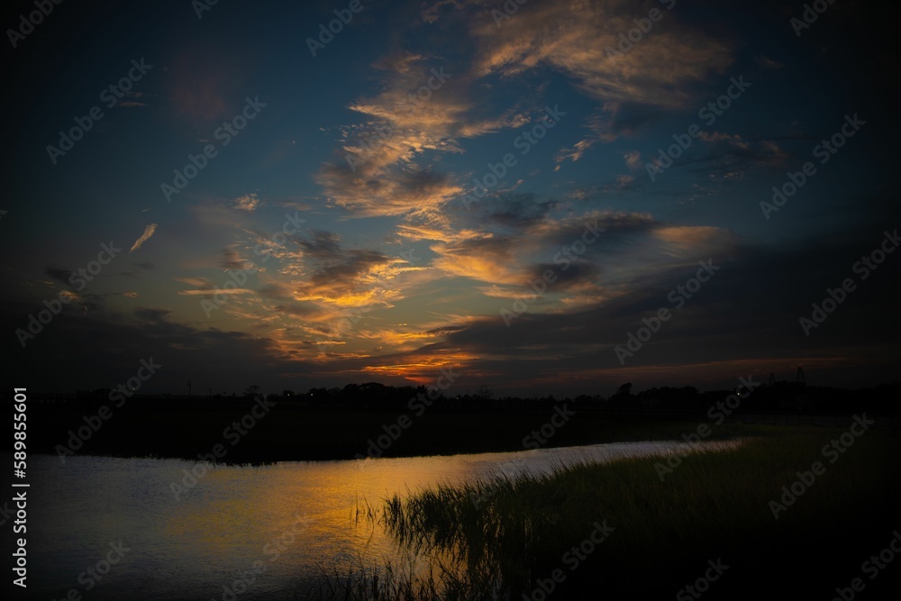 Beautiful sunset on Shem creek with a cloudy blue sky in the background, South Carolina
