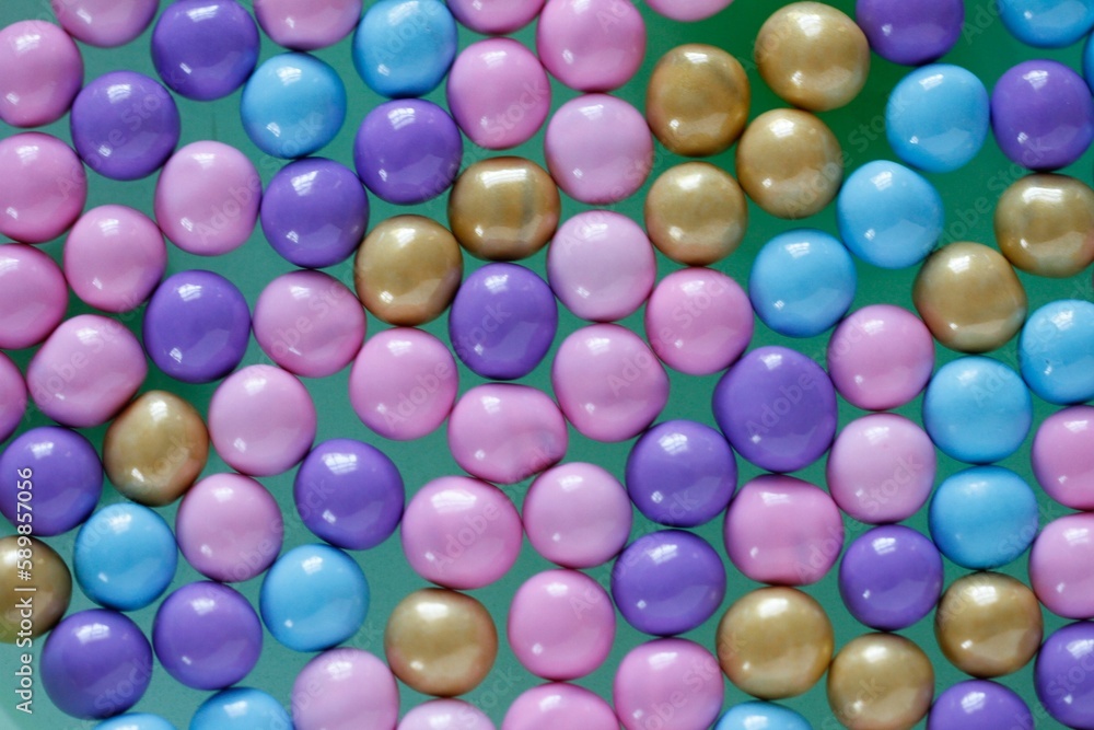 Top view shot of small colorful circle-shaped candies on a green surface Top view shot of small colorful circle-shaped candies on a green surface