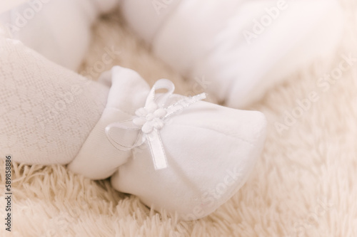 A small child's foot in a white slipper