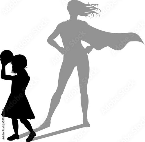 A superhero child or kid girl revealed by her shadow silhouette as a super hero in a cape.