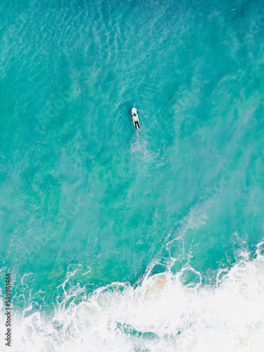 Obraz na płótnie View from above, stunning aerial view of a person surfing on a turquoise ocean. Fuerteventura, Canary Islands, Spain. w salonie